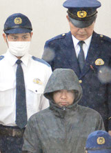 黒のフードを深くかぶって送致された前竹容疑者=19日午後、八重山署