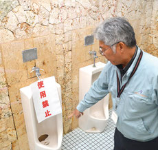 16日に破損を確認した便器の穴。他にも外壁の被害や、たき火と思われる跡もあった=16日、同公園