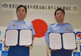 協定書に署名した宇根消防長(左)と与那嶺署長=14日、八重山署