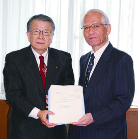 答申を手交する安里会長(写真左)と受け取る浦崎副知事=26日、県庁