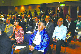 尖閣諸島開拓の日式典に参加し、登壇者のあいさつを聞く人たち=14日午後、市民会館大ホール