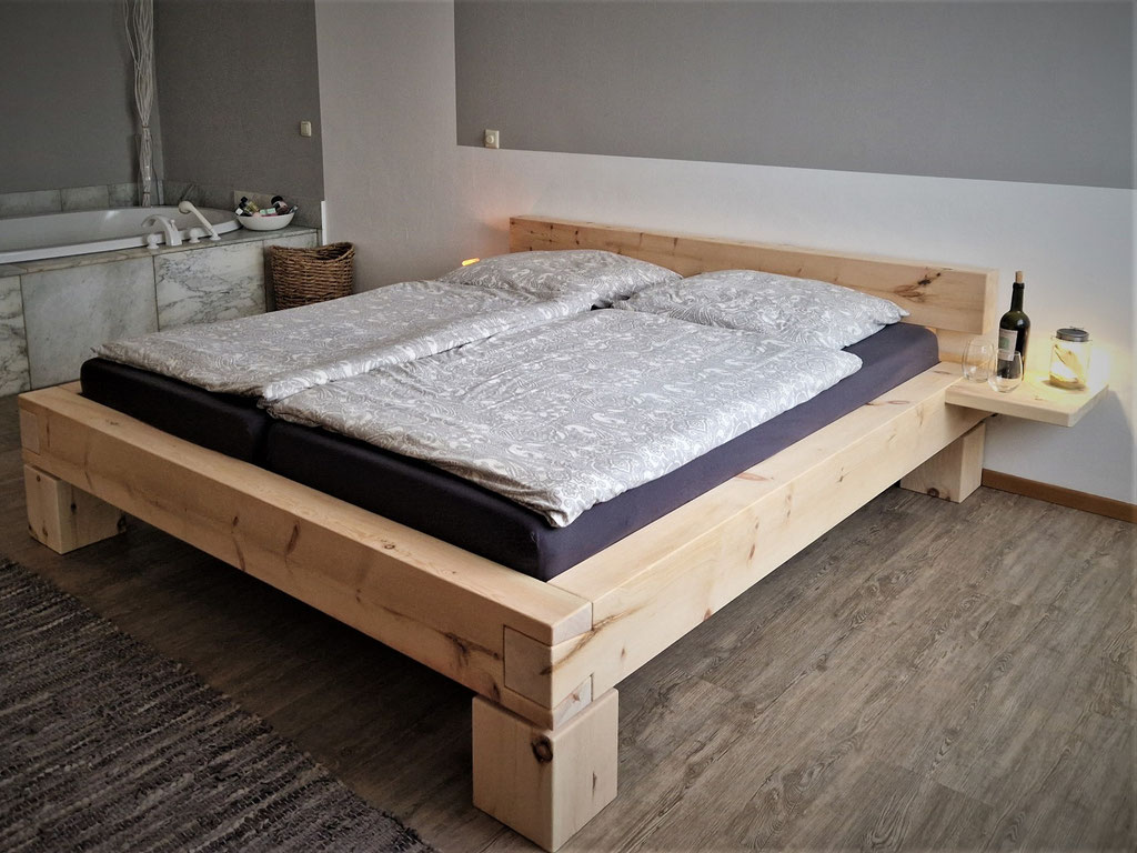 Massives Zirbenbett mit Kopfteil aus Zirbenholz im Schlafzimmer