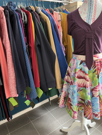 Lila Top mit bunten Rock vor Kleiderstange. ChaWe-Naturmode