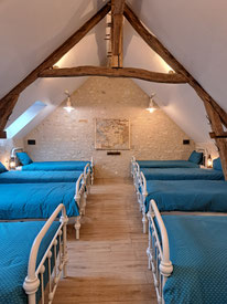  Le dortoir du Grand Roc ravira petits et grands avec les 8 lits en fer blanc et les lampes tempêtes ainsi que l'ambiance chaleureuse apportée par la charpente et le mur en pierres apparentes