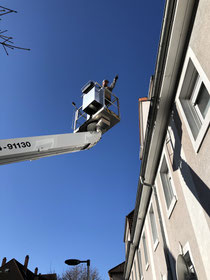 alt-text: Dachdecker mit Hebebühne für Dachfensteraustausch