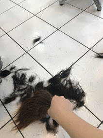 ロングの髪を切って掃除するショートボブにする女性の画像