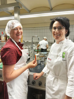 Trainerin Monika Sohneg mit Teilnehmerin lachend in der Ausbildungsküche des WIFI Linz