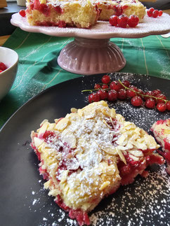 Johannisbeer Blechkuchen Stücke auf der Tortenplatte und auf dem Teller