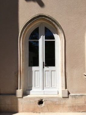 porte fenêtre en ogive en bois exotique peint en blanc avec une poignée modèle Nevers 