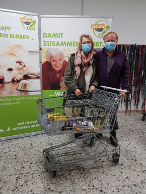 Einkaufswagen vollFutterspenden mit Ehepaar