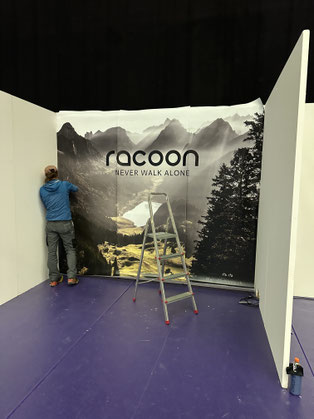 Fototapete Alpstein, Messestand racoon Rucksäcke