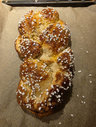 Fertig gebackener Hefezopf noch warm auf dem Blech