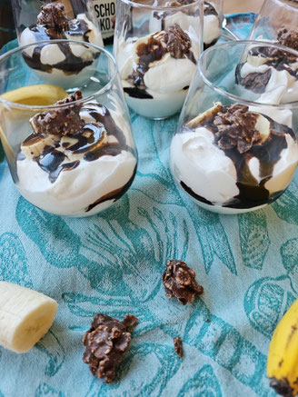 Banana-Split-Dessert im Glas mit Banane, Creme und Schokolade