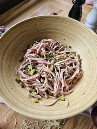Klassischer Wurstsalat mit Zwiebeln, Gewürzgurken und frischen Kräutern