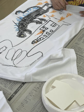 小児病棟Tシャツワークショップで子どもがシャツに絵を描いている