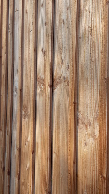 Bardage traditionnel en planches et couvre joints brutes sur bâtiment agricole