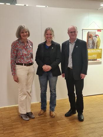 Dr. Christine Sauer, Dr. Cathèrine Conradty und Dr. Norbert Schäffer stehen vor dem Plakat der Ausstellung