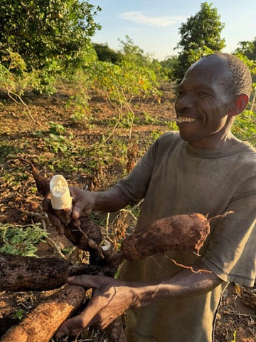 Lachender Mann mit einer angebissenen Frucht in der Hand