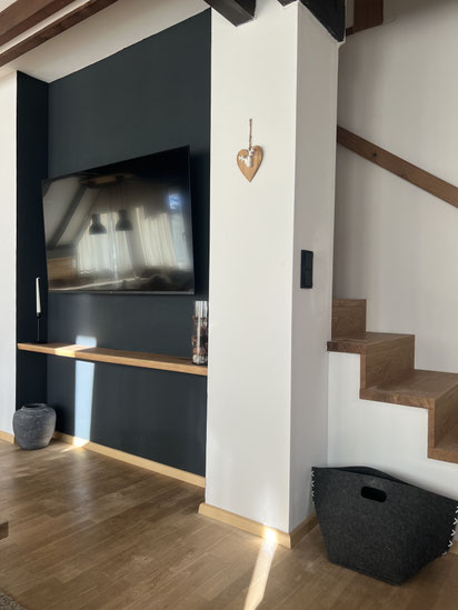 Fernsehwand im Wohnzimmer mit Treppenaufgang