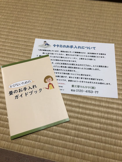 畳のお手入れガイドブックを手渡しながらお客様に説明している様子