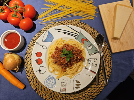 Klassische Spaghetti Bolognese wie bei Mama auf einem weißen Pastateller serviert 