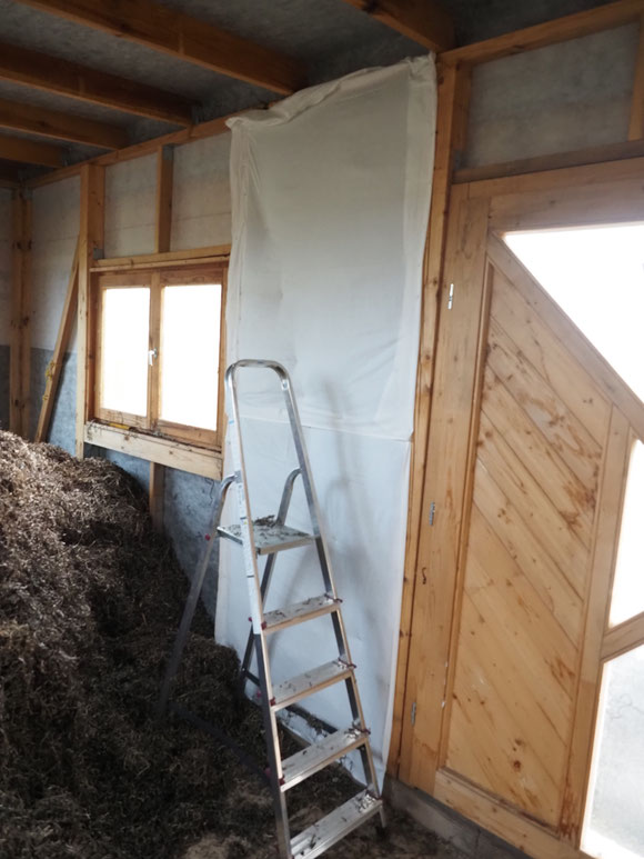 Seegras locker in die Gefachung eingebracht, dann wird die 12 cm Dämmung mit einem alten Lacken abgesteppt und getackert, später wenn alles fertig gedämmt ist, kommt noch da noch eine 2 cm Holztäfelung als Wandbaschluß drauf.