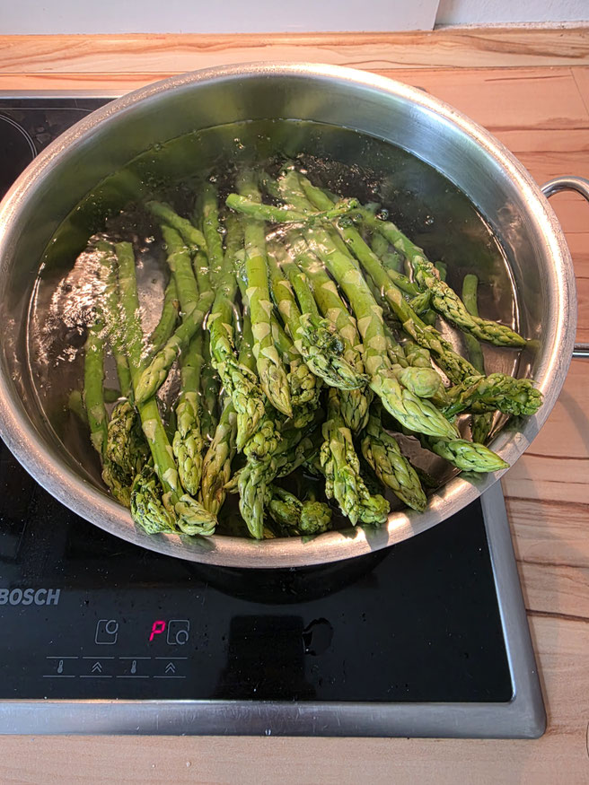 Grüner Spargel im Topf mit kochendem Wasser beim blanchieren