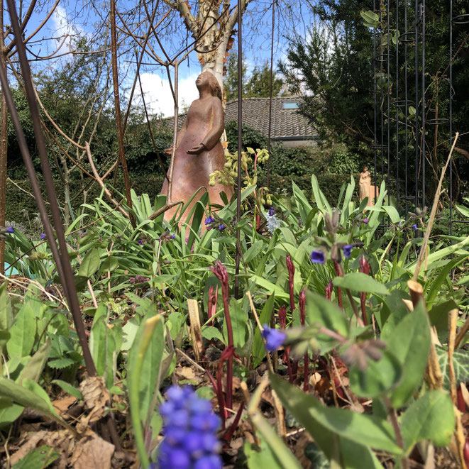 Gartenskuptur Holzbrand im Garten im Frühling