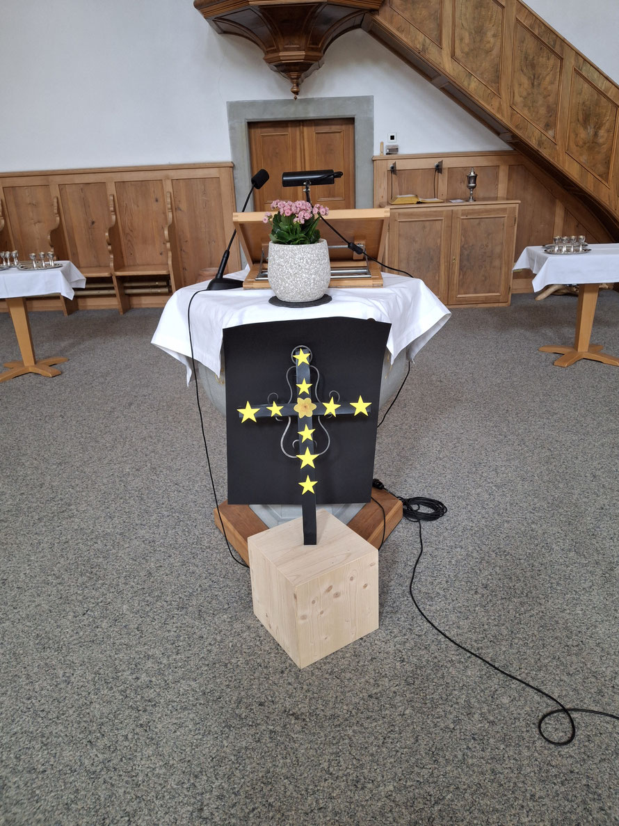 Metallkreuz geschmückt zum Neunsternekreuz mit Osterglocke