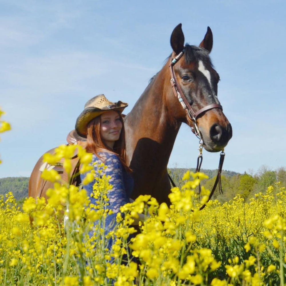 Mein Name ist Christine Wallerich und seit meinem 10. Lebensjahr begleiten mich Pferde durch mein Leben. 2015 habe ich meine Liebe zu Pferden entdeckt und auf einem kleinen Reiterhof das Reiten erlernt. Zwischen 2017 und 2019 war ich im Englischen Reitstil unterwegs und ritt auf Niveau E/A. In dieser Zeit absolvierte ich erfolgreich mehrere Reitabzeichen, unter anderem das RA9, RA7 und RA5.    Anfang 2020 begann ich auf einem kleinen Reiterhof, mit Kindern zu arbeiten. Dort bereitete ich junge Reiterinnen und Reiter auf die kleinen Reitabzeichen vor und vermittelte ihnen Schritt für Schritt die Grundlagen des Reitens.    2021 entschied ich mich, zu Martina und Alex zu wechseln. Hier habe ich meine Reitbeteiligung Aqui gefunden – und damit auch meine Begeisterung für das Westernreiten entdeckt.  Seit 2025 unterstütze ich Martina und Alex im Ponyclub, wo ich meine Leidenschaft für Pferde und die Arbeit mit Kindern miteinander verbinden kann.    Ich freue mich sehr darauf, euch kennenzulernen!