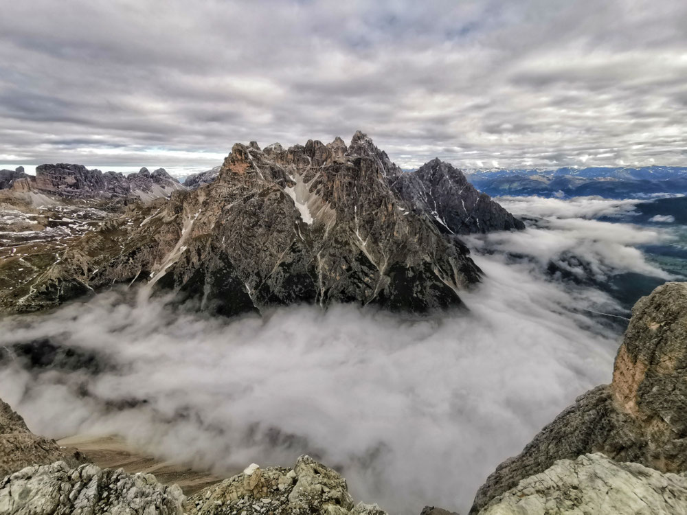 Eine dicke Wolkendecke liegt unterhalb des Gipfels