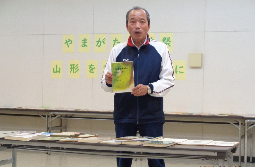須長さんの著書「トカゲのしっぽ」を持つ最上一平さん