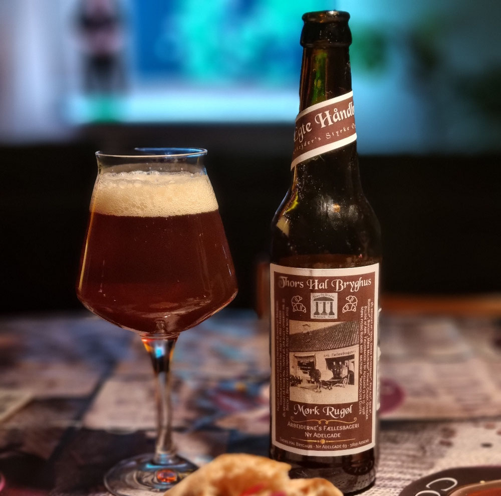 Øl nr. 21 - Dansk Mørk Rugøl - en hyldest til Arbejderne's Fællesbageri på Ny Adelgade 13-18 i Assens. Mørk malt sirup, Galaxy humle, rød X malt, rugmalt og biscuit giver en mørk kraftfuld Rugøl, med en duft af sødt brød og frugt. Dansk Pilsnermalt og Pale Ale malt giver masser af styrke. Brygget på engelsk ale gær. Alk. 7,5% Vol.  EN ARBEJDER'S ØL, SOM ER ET MÅLTID I SIG SELV. 