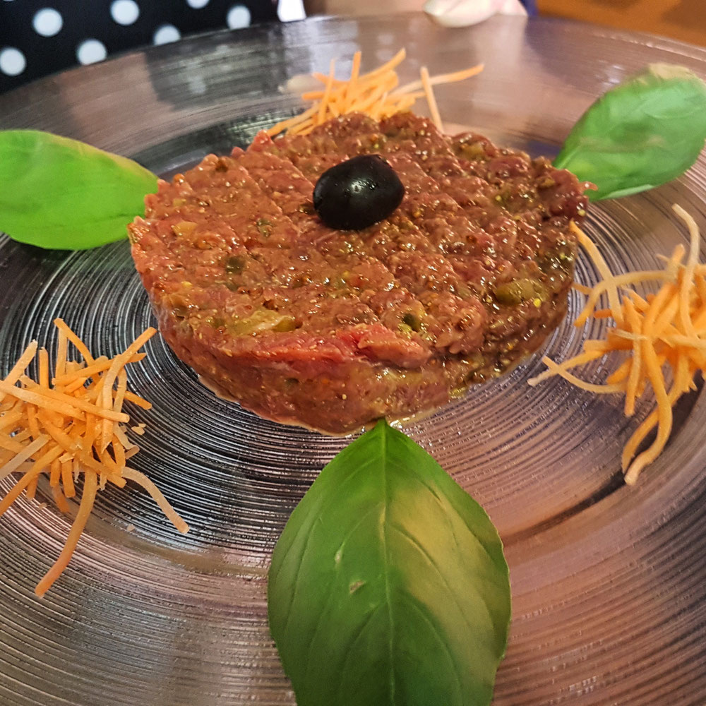 Tartare de boeuf servie avec frites, salade et toasts à 25 frs 