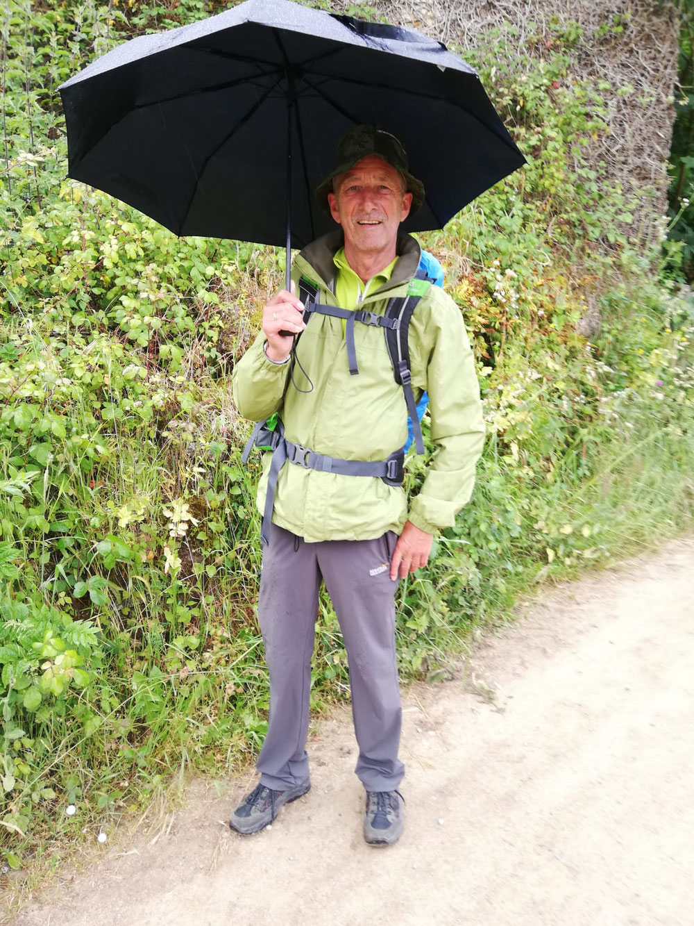 Willi mit Schirm und ich im Poncho.