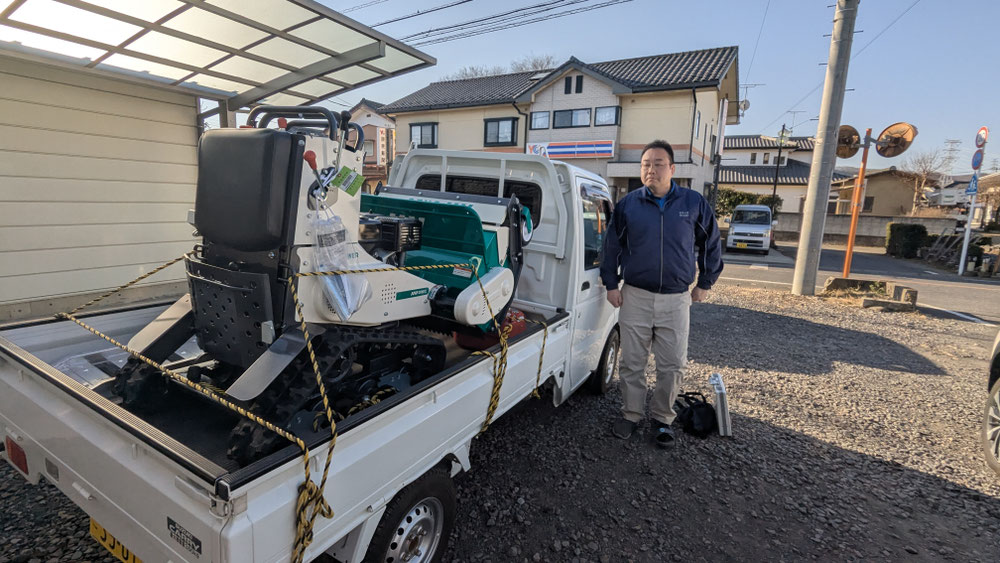 群馬・両毛エリアの現場で軽トラックと機械とともに立つスタッフ
