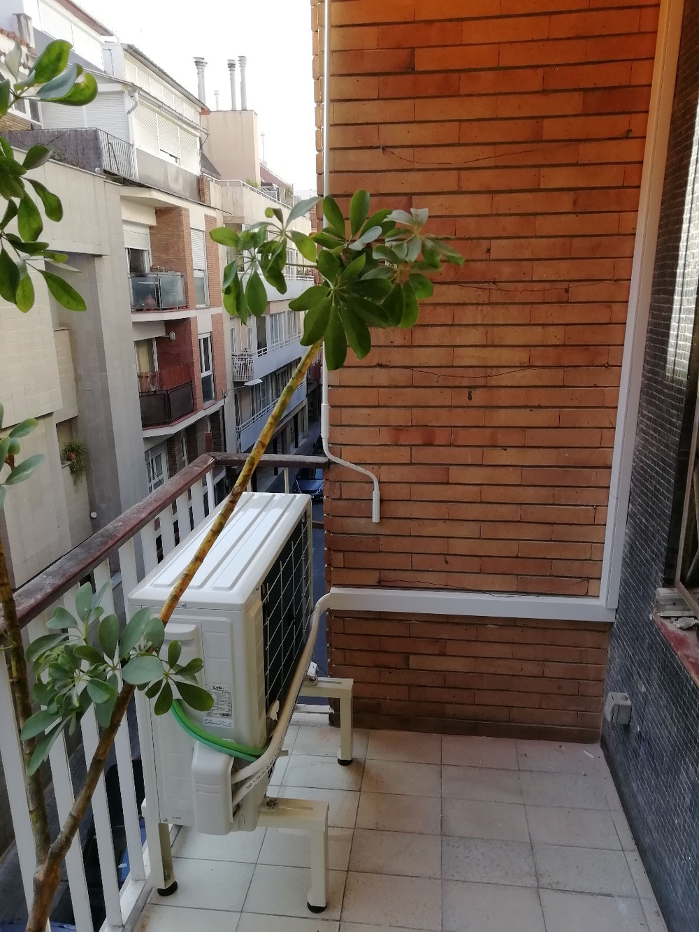 Instal·lació de equip condensador en balcó amb canaleta decorativa per amagar tuberies.