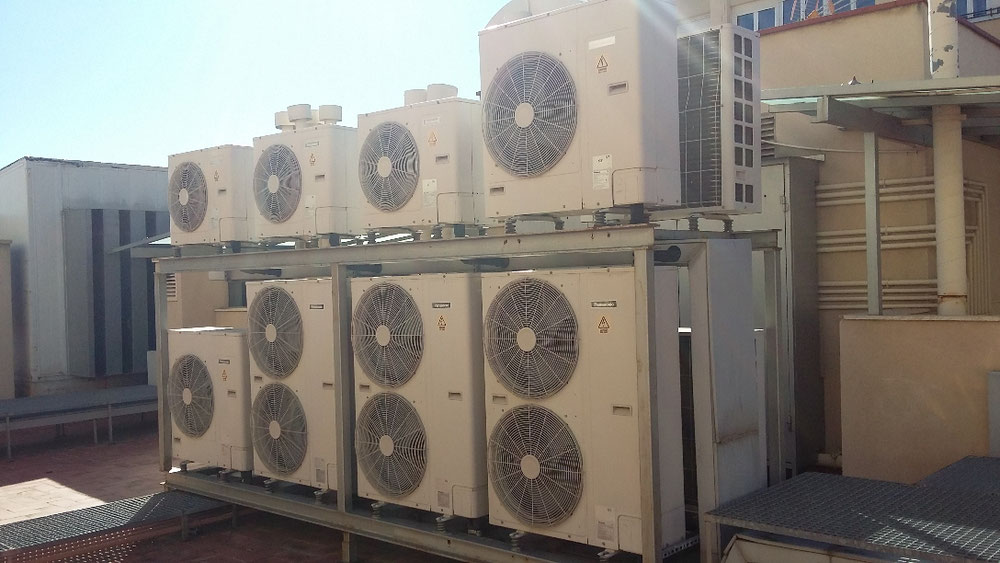 Instal·lació d'equips condensadors en terrat comunitari amb soportació feta a mida antivibracions i anticaigudes per fort vent.