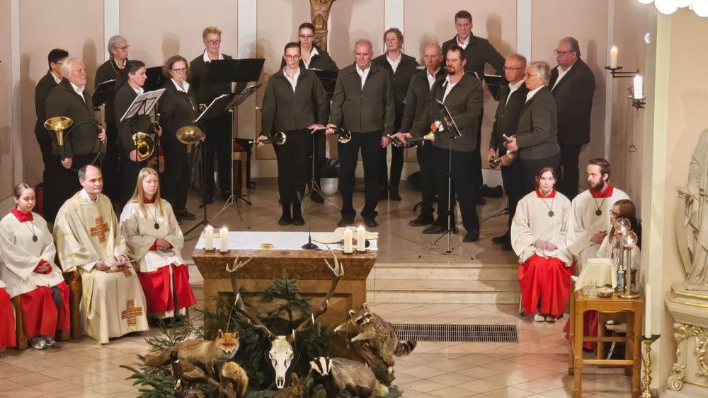 Das Fotos zeigt den Altarraum der Kirche St. Josef hinter mit ausgestopftem Wild geschmückten Altar der Zelebrant, Ministranten und das Bläserkorps Buschmannshof zu sehen sind.