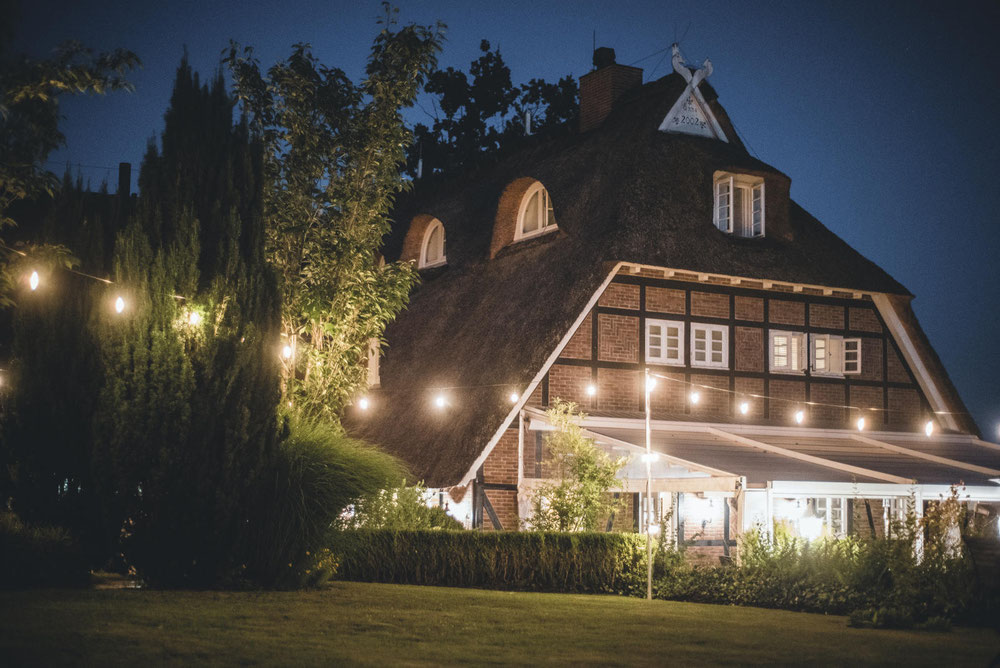 Fachwerkhaus im Abendlicht, die Terrasse ist beleuchtet