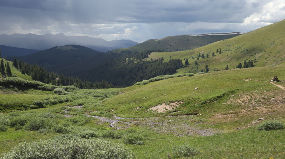 Blick vom Kokoma Pass hinunter ins Tal mit isolierten Gewitter