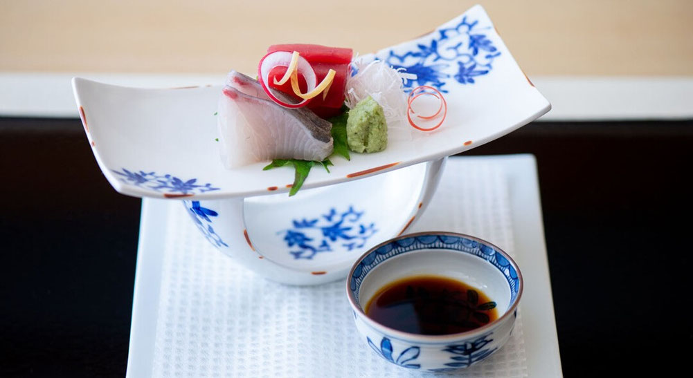 Refined sashimi course in Japanese kaiseki dining with elegant plating.