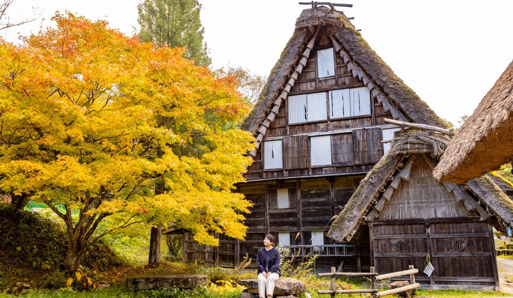 Interior of traditional farmhouse with wooden beams and irori hearth at Hida Folk Village.