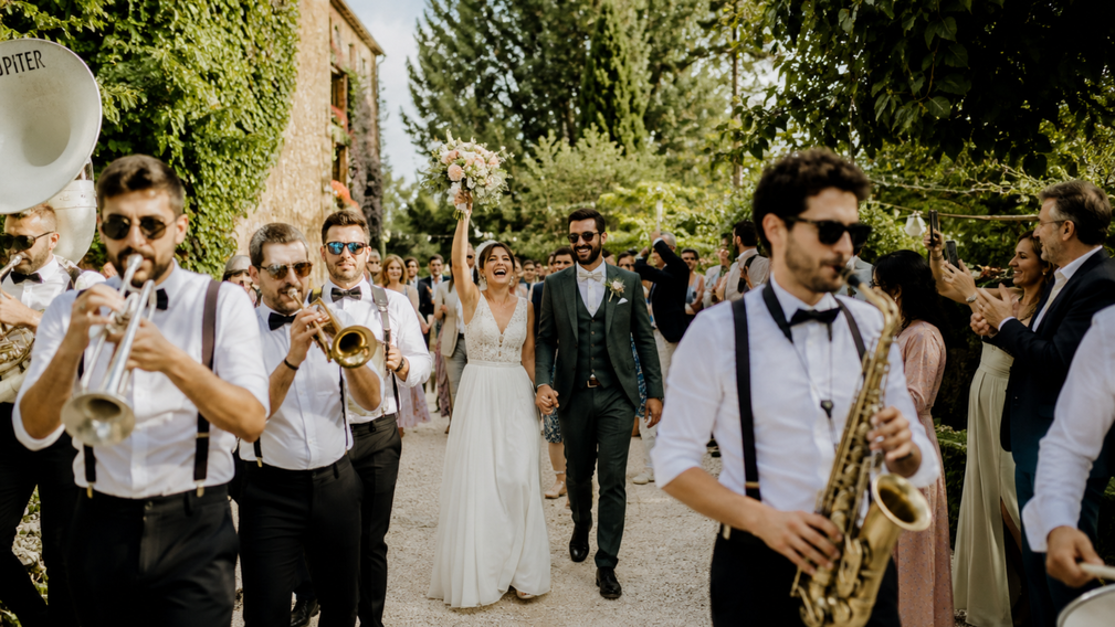 L’arrivée des mariés au son d’une fanfare : une entrée festive et inoubliable - Magazine Un Jour Un Oui - Crédit photo : Tous droits réservés