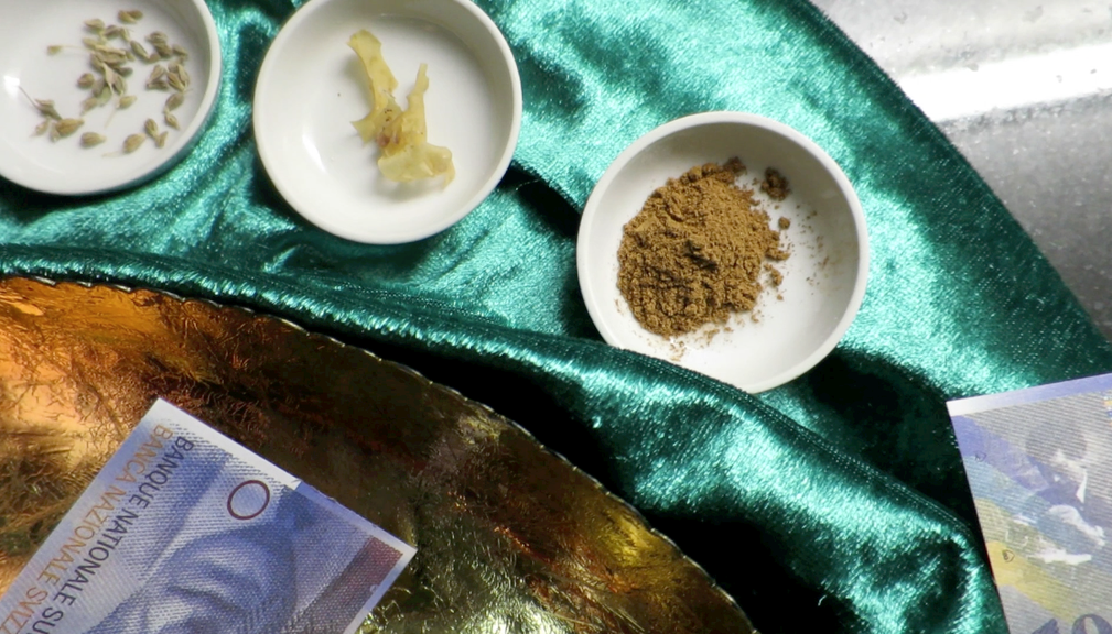 Draufsicht auf drei keine weisse Teller mit Gewürzen darin. Auf einem grünen Samttuch liegt ein goldener teller mit Banknoten auf dem Tisch.