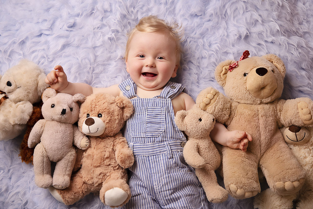 Babyfoto Paderborn lachender Junge mit Teddys
