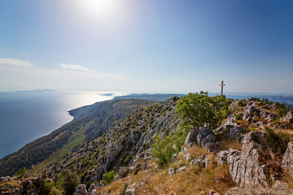 Gipfelkreuz auf dem Berg Sveti Nikola mit Blick auf das Meer im Westen.