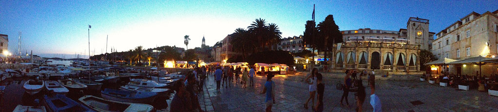 Prächtige venezianische Loggia im Sonnenuntergang an der Hafenpromenade der Stadt Hvar. Kleine Fischerboote im Hafen
