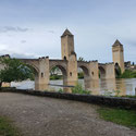 Pont de Valentré par temps nuageux mais lumineux avec les reflets du fleuve du Lot