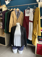 Blazer und Kleider auf Kleiderstange drapiert. ChaWe-Naturmode